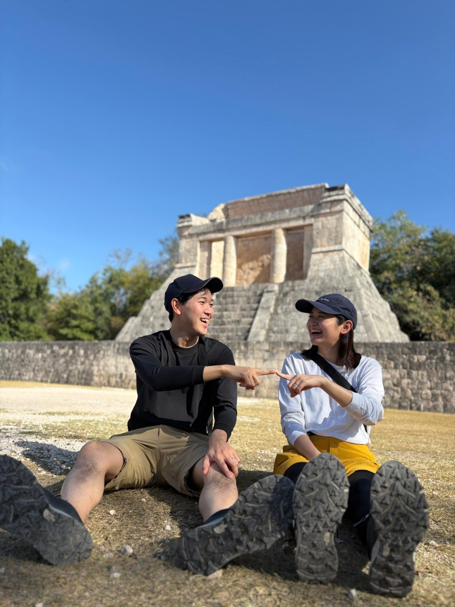 Couple laughing together in front of an ancient Maya temple at Chichen Itza