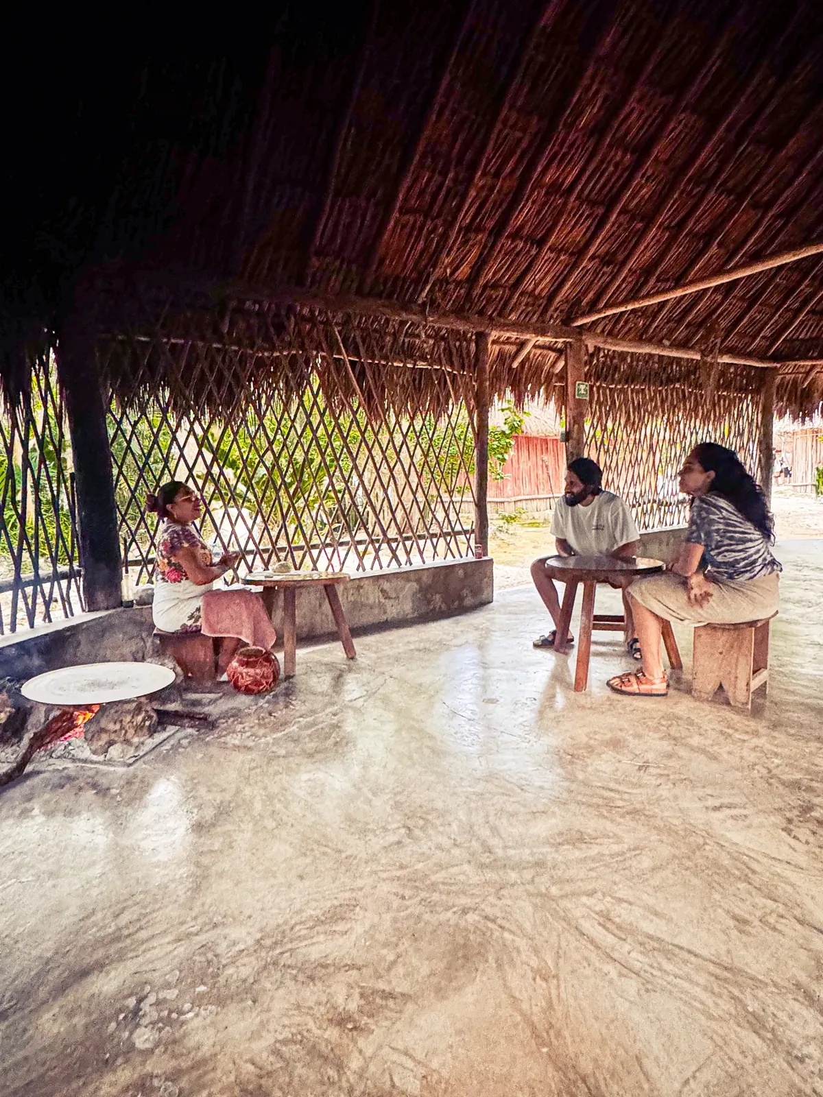 Guests sharing a meal in a rustic open-air dining area